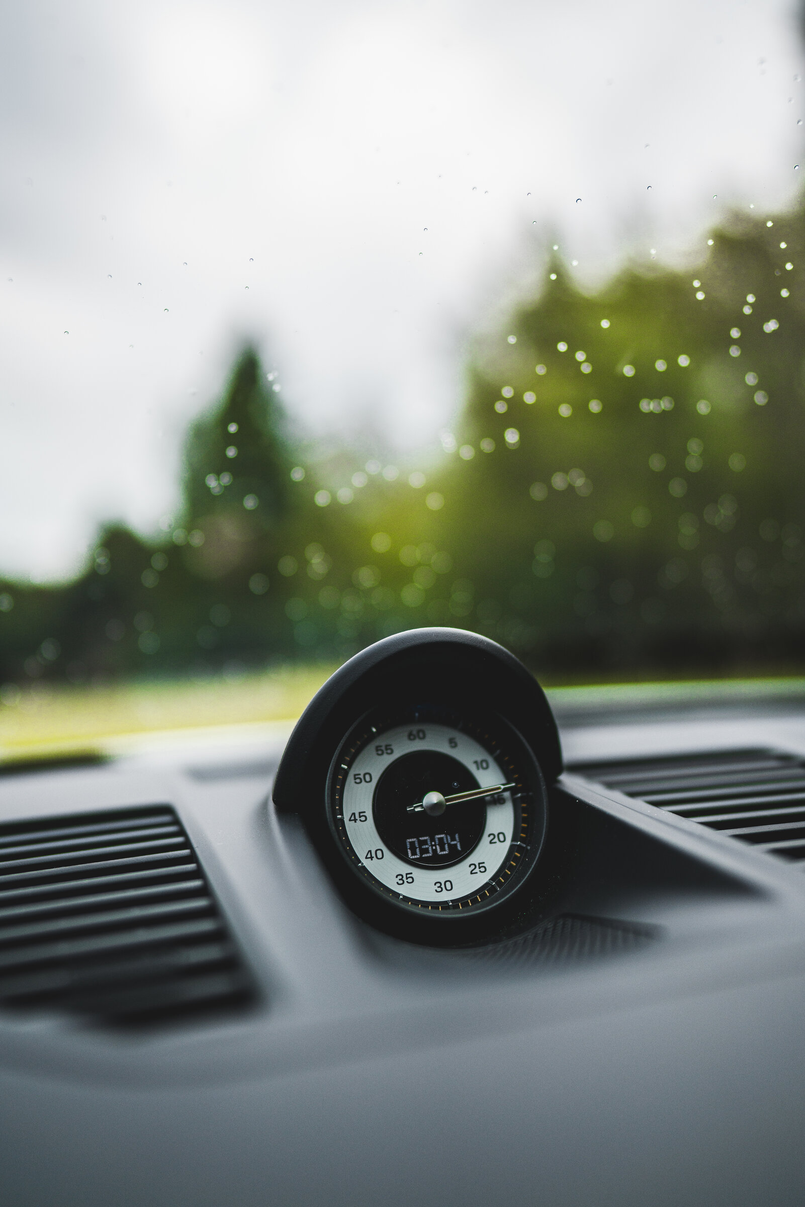 Dashboard clock detail on a rainy day