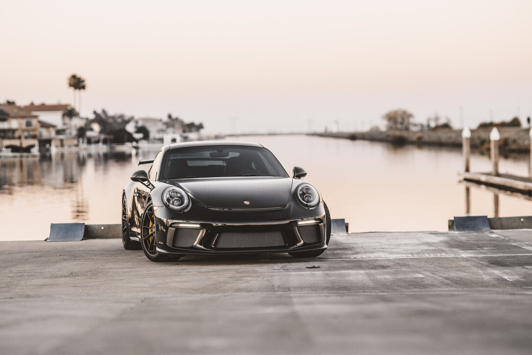 Porsche GT3 at a marina dock at dusk